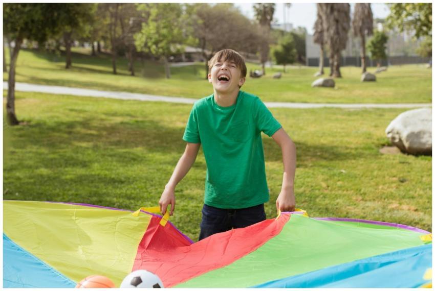 Laughing boy in green shirt playing with colorful