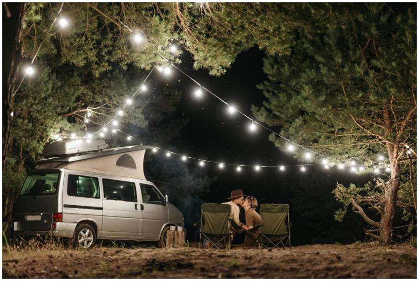 Couple sitting by a campervan enjoying a romantic