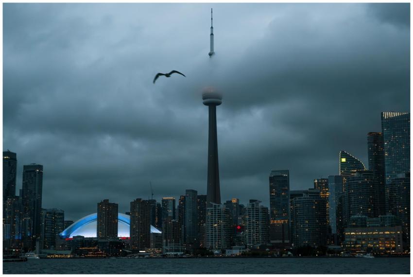 Toronto skyline featuring CN Tower shrouded in clo