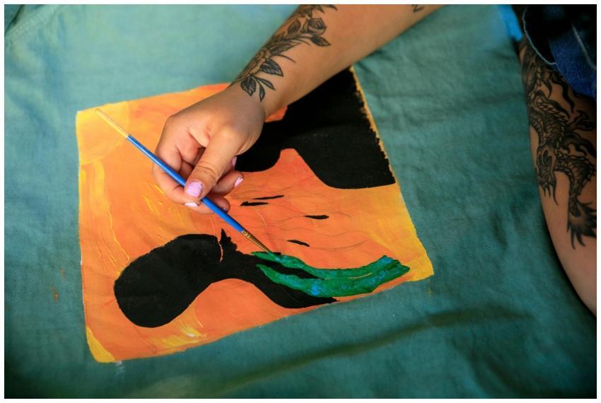 Artist with tattoos painting vibrant abstract art