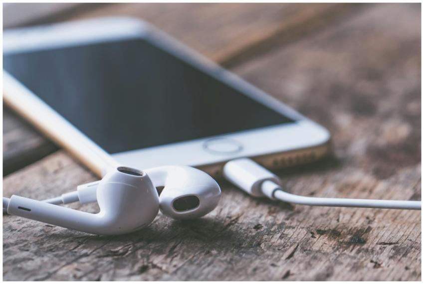 A close-up image of a smartphone and earphones lyi