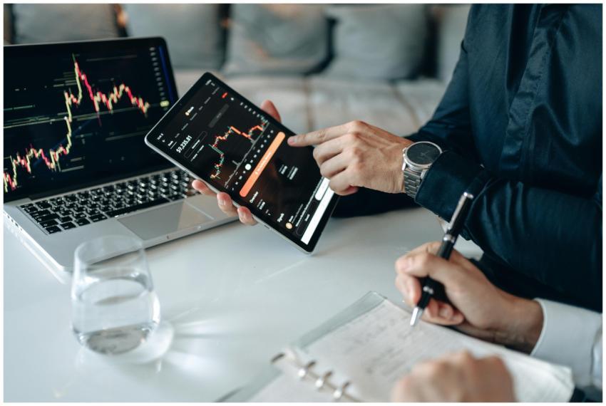 Two professionals analyzing stock graphs on digita