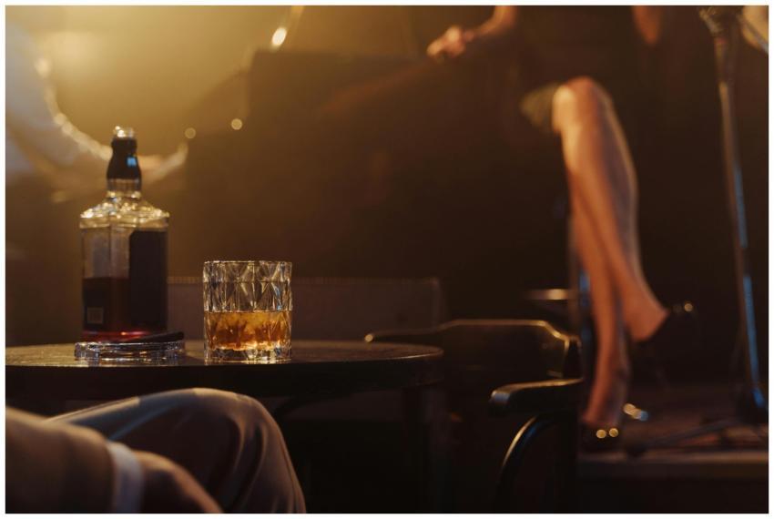A glass of whiskey on a table with live jazz music