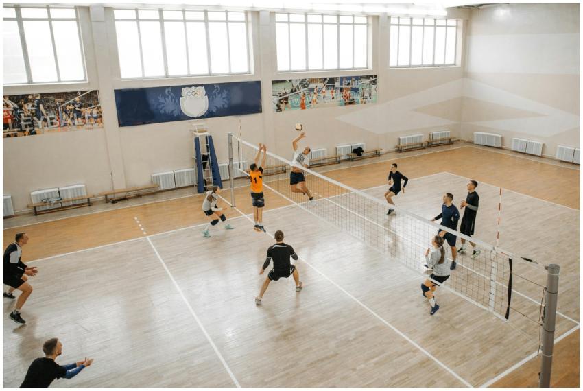 Competitive volleyball match with players jumping