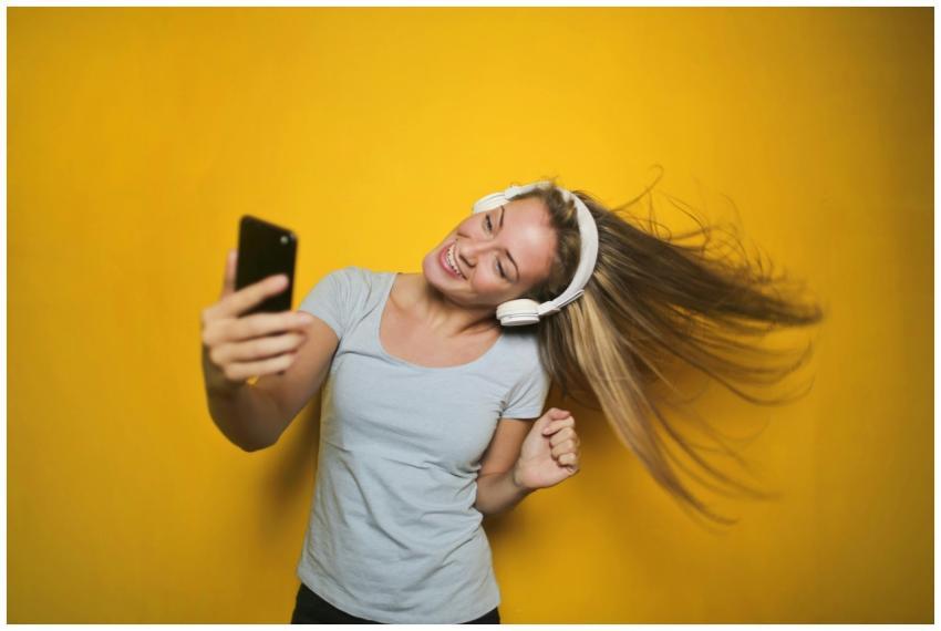 Cheerful woman wearing headphones, enjoying music