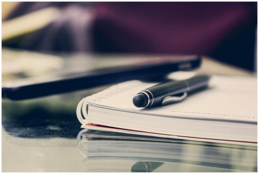 Close-up of an elegant pen resting on an open note