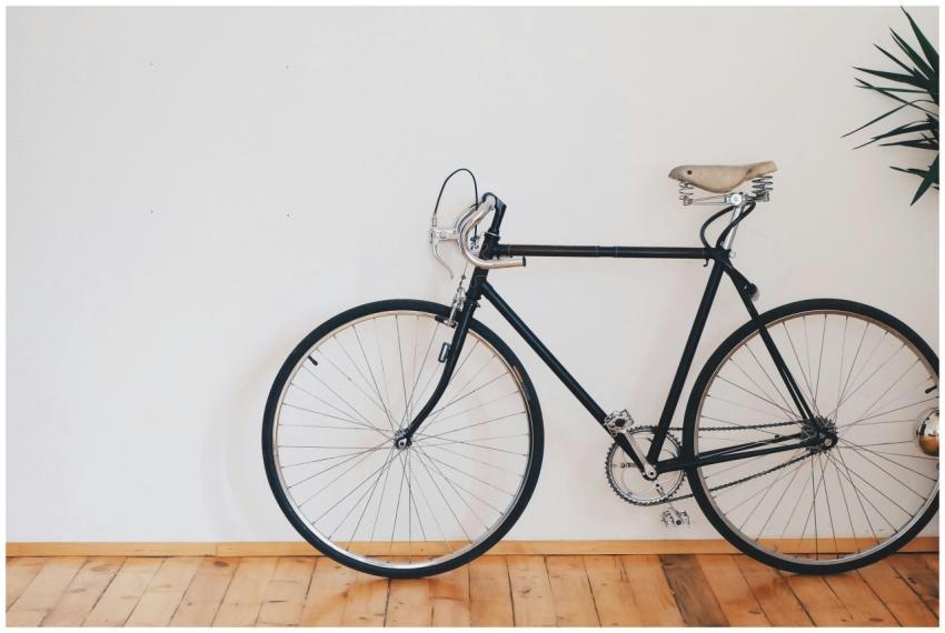 A vintage-style bicycle leaning against a clean wh
