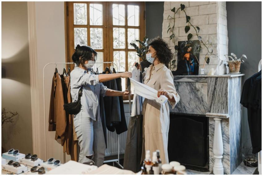 Two women wearing masks shopping in a boutique dur
