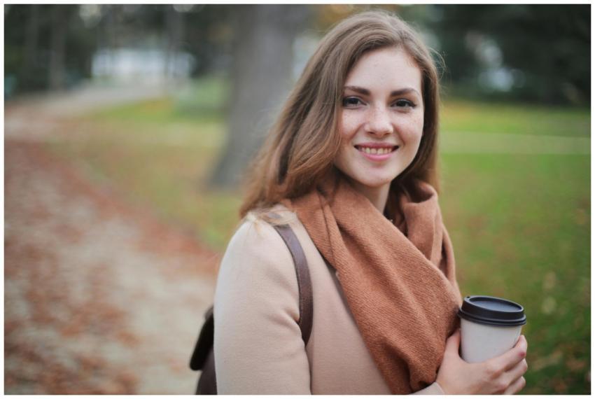 Portrait of a smiling woman holding a coffee cup i