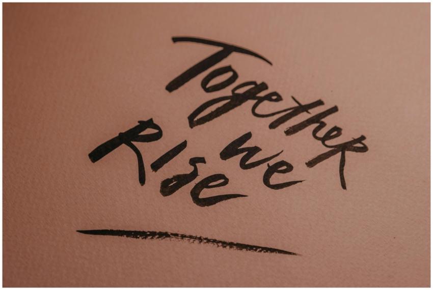 Close-up of hand-lettered 'Together we Rise' on a