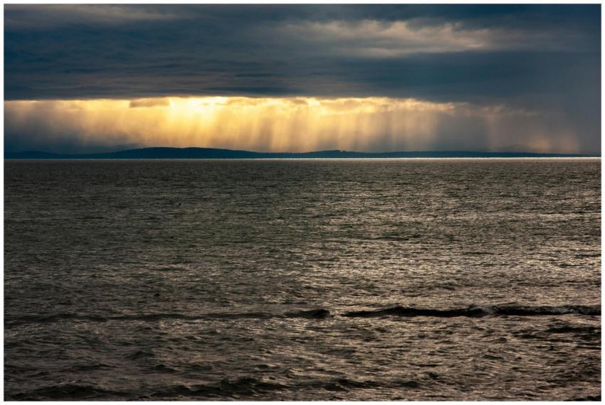 Sunbeams break through overcast clouds, casting li