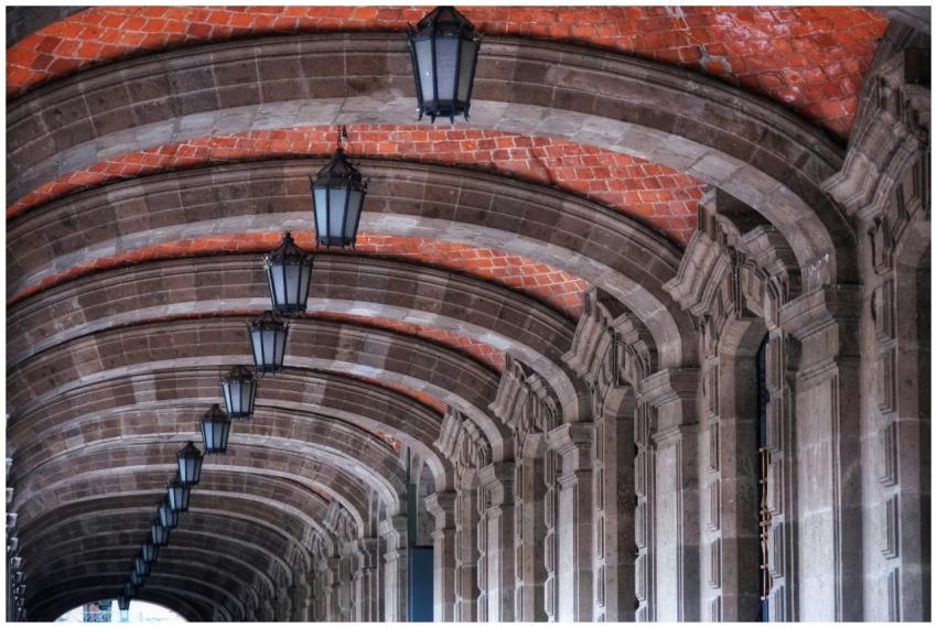 Detailed view of stone arches with lamps in Cuauht