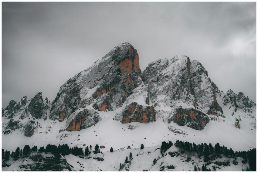 Majestic snow-capped mountains with trees, under a