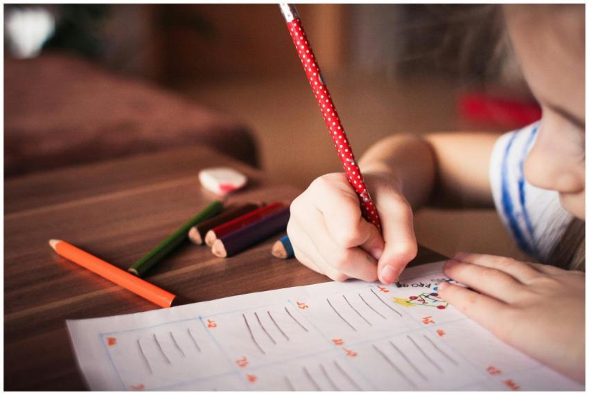 Close-up of a child completing homework using colo