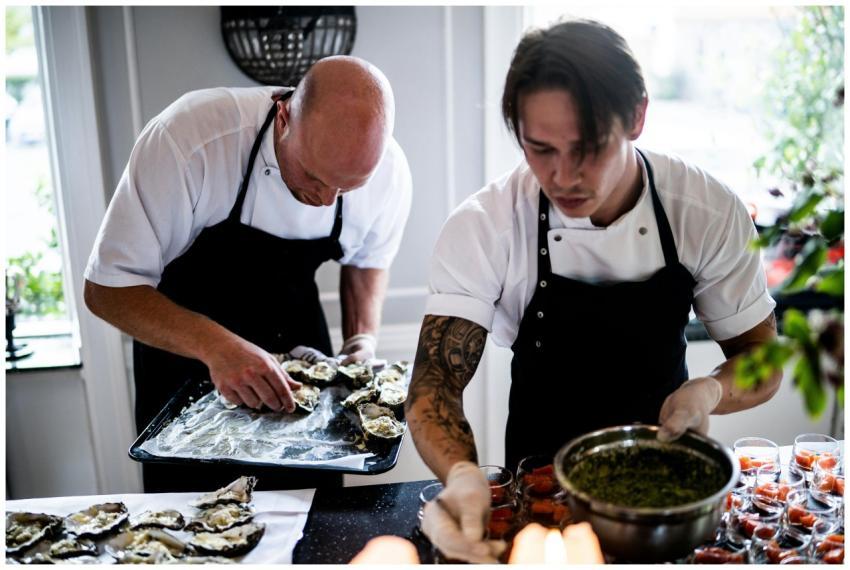 Two chefs in a restaurant kitchen preparing gourme