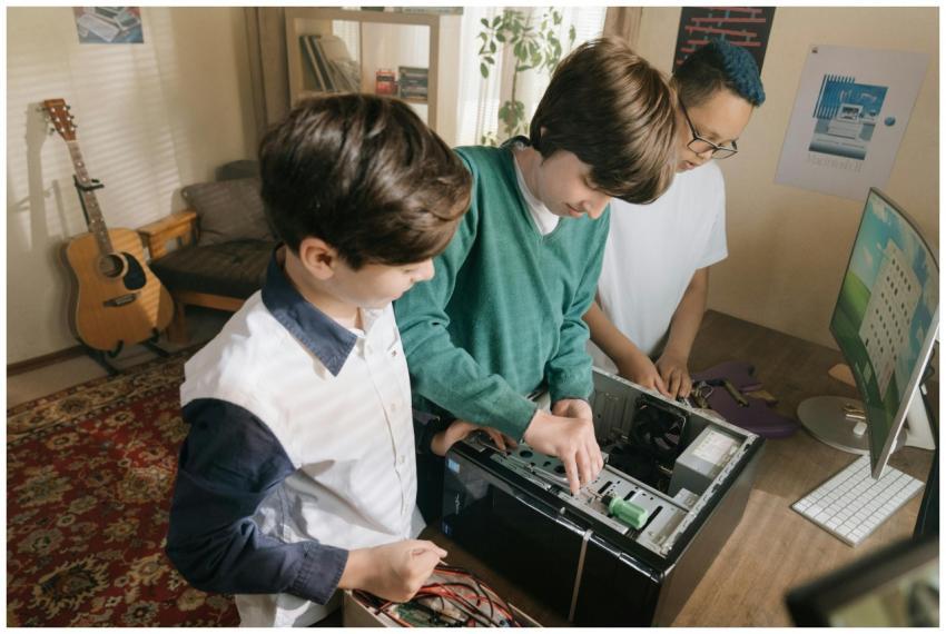Kids working together assembling a computer indoor
