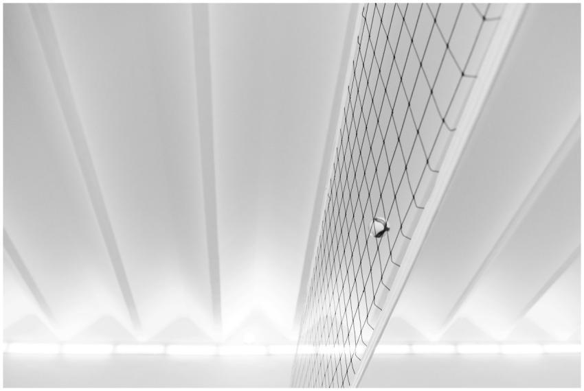 A modern minimalist shot of a volleyball and net i