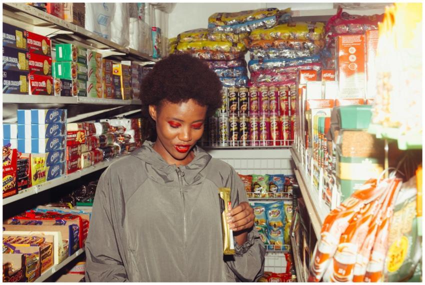 A smiling woman examines products in a colorful gr