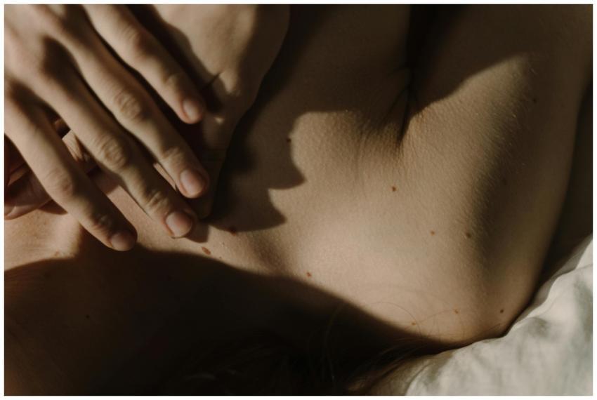 A gentle hand resting on skin with soft natural li