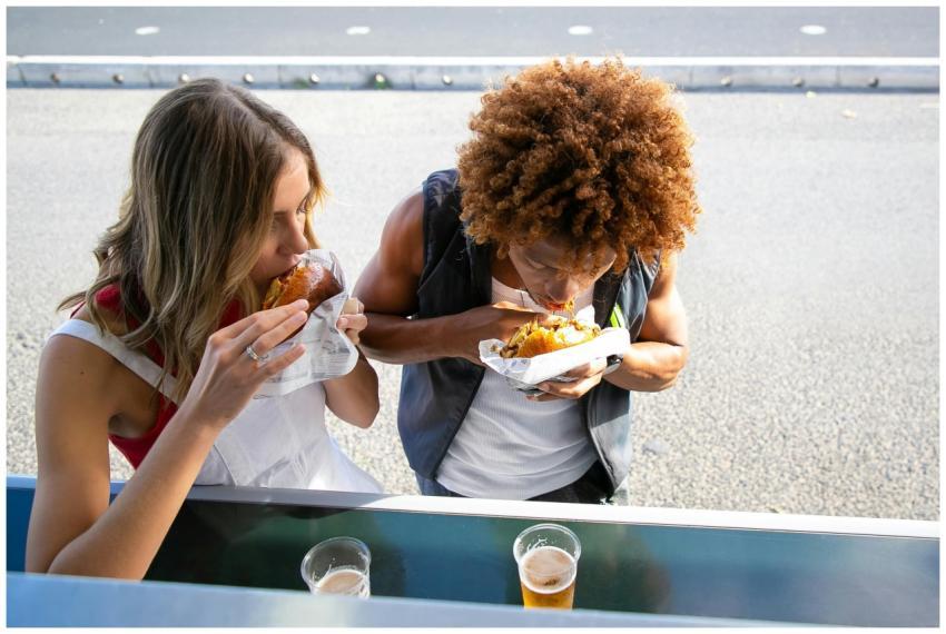 Two people enjoying tasty burgers and drinks at a