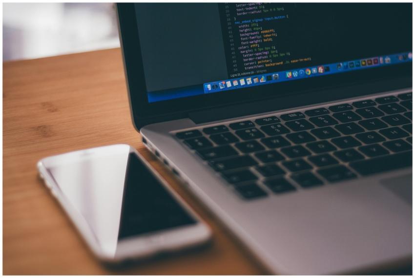 Coding setup with laptop displaying code and smart