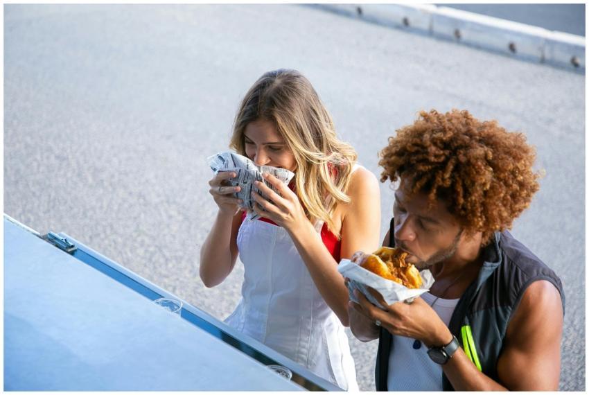High angle of diverse hungry couple having lunch w