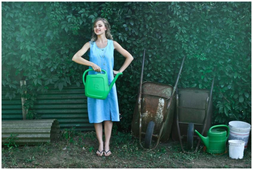 Young woman in a blue dress holding a green wateri