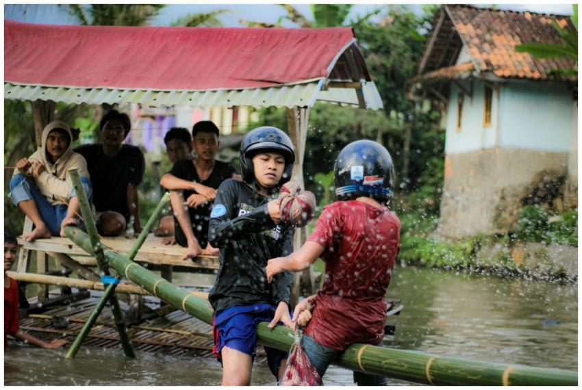 Boys engaging in a playful challenge on a bamboo r