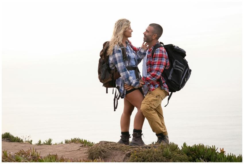A couple embraces on a cliffside hiking trail in P