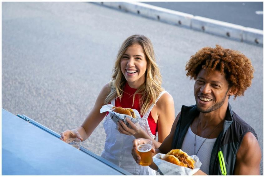 Happy couple enjoying burgers and drinks at a food