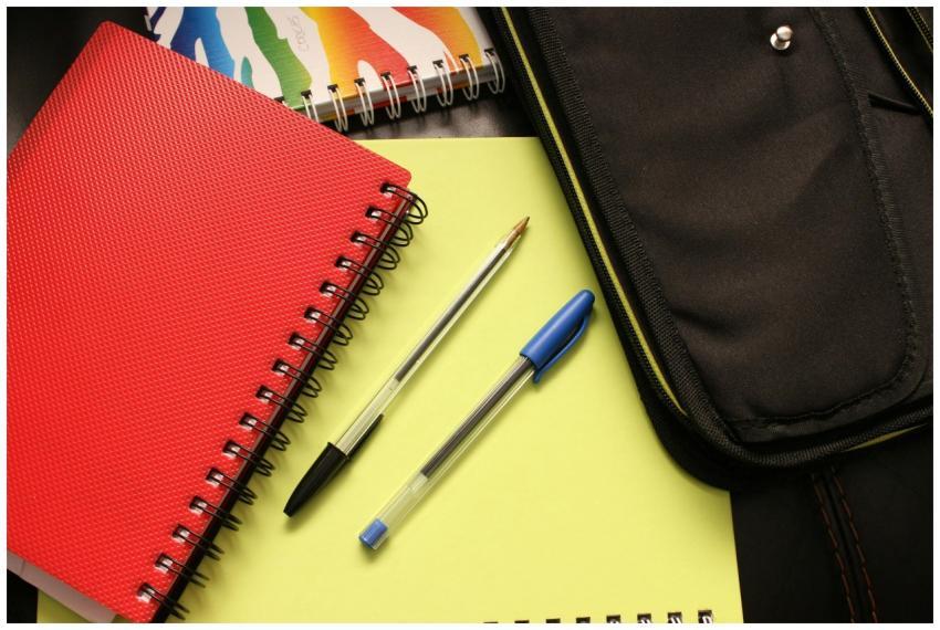 A close-up view of colorful notebooks and pens, pe