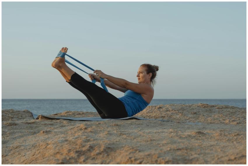 A woman performs yoga stretches on a mat near the