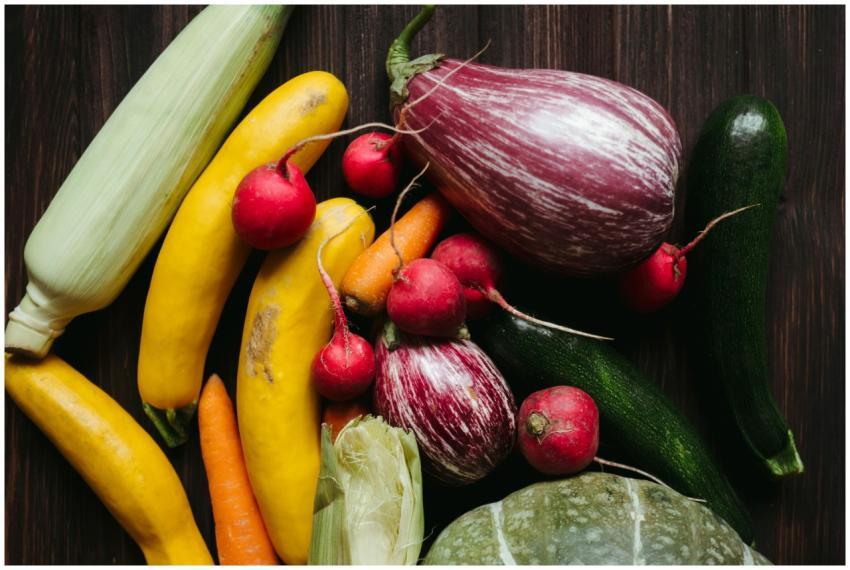 A vivid array of fresh vegetables on a dark wooden