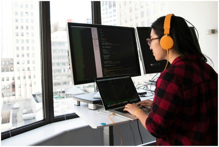 Woman programming on a laptop at a standing desk i