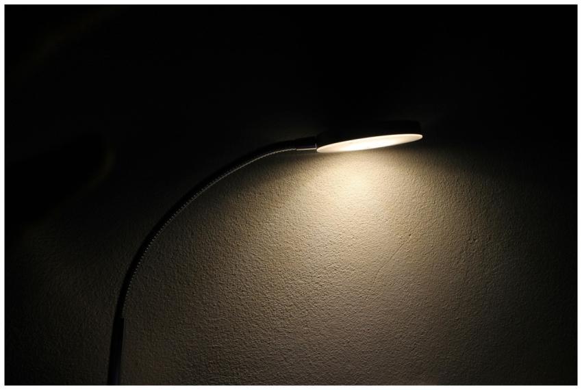 A sleek desk lamp casts a soft glow on a textured