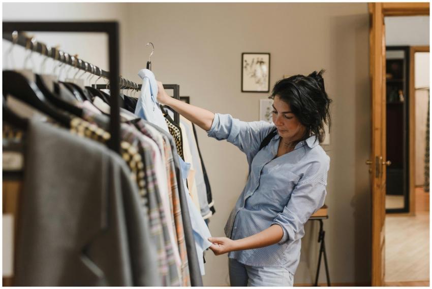 A woman examines clothes on a rack in a stylish bo