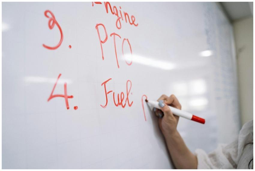 Close-up view of a hand writing with a red marker