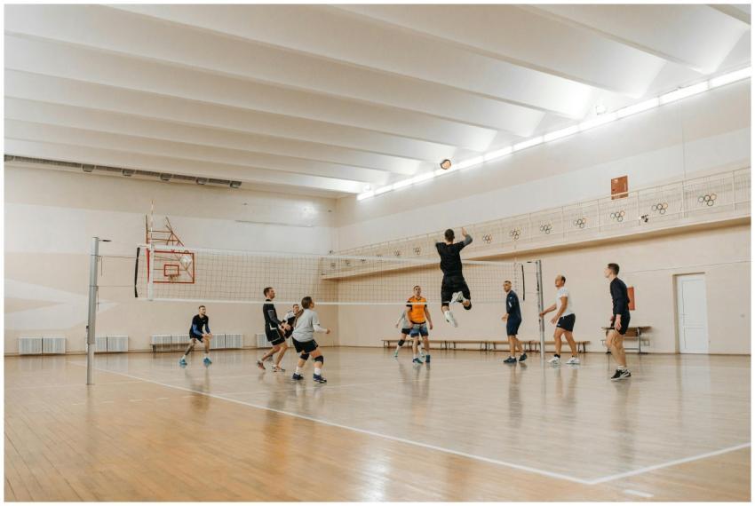 Players in an intense volleyball match indoors, sh
