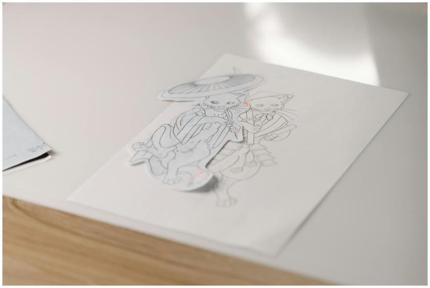 Artistic sketch of cats holding an umbrella on a s