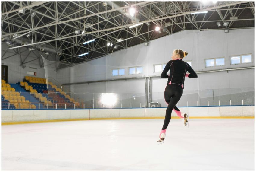 A figure skater executes a jump on an indoor ice r