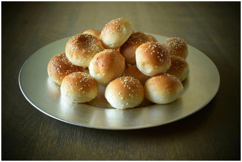 A stack of freshly baked sesame bread buns display