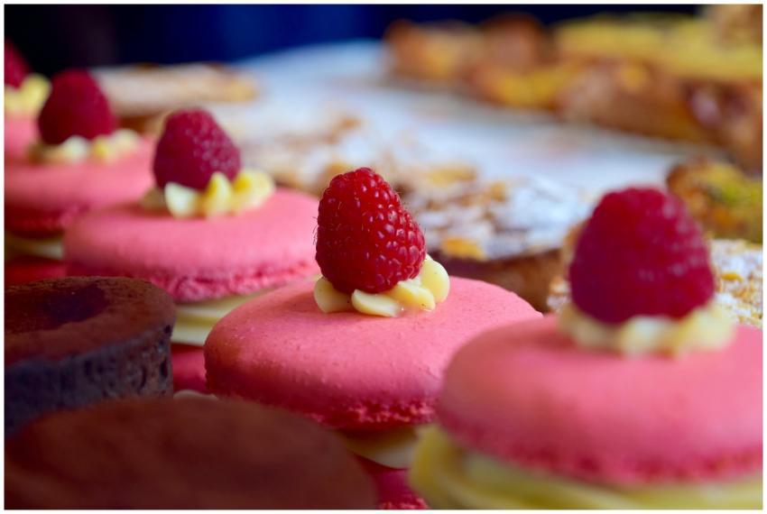Close-up of pink macarons topped with raspberries,