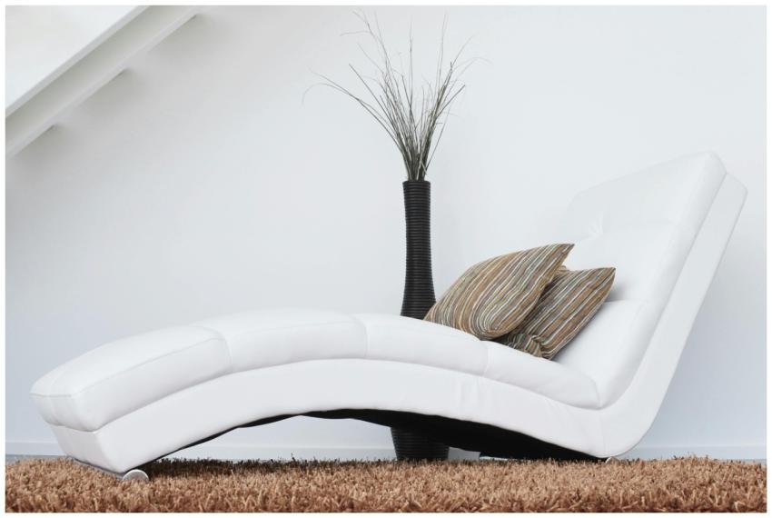 Elegant white lounge chair with cushions on plush