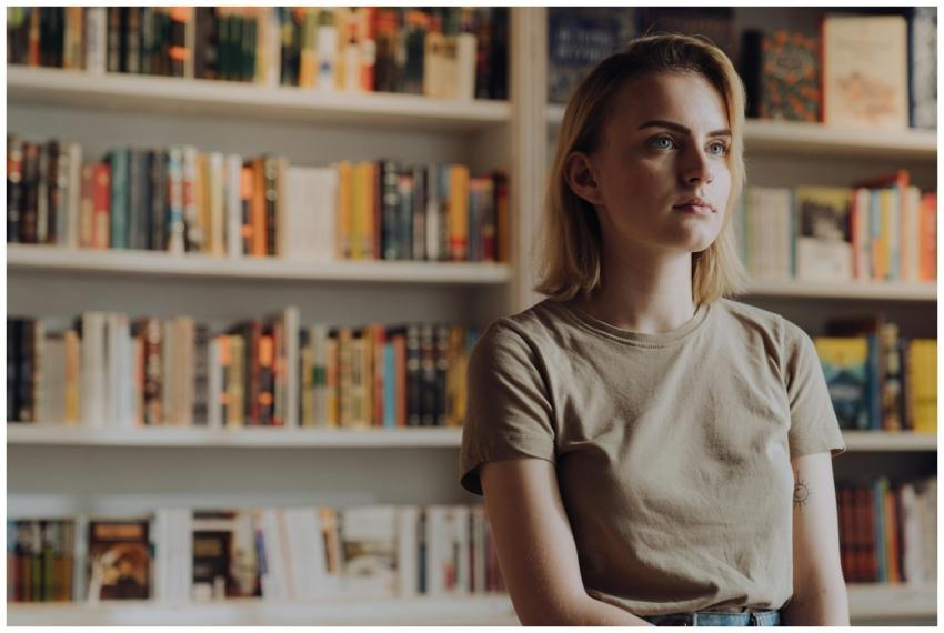 A young woman stands in a bookstore surrounded by