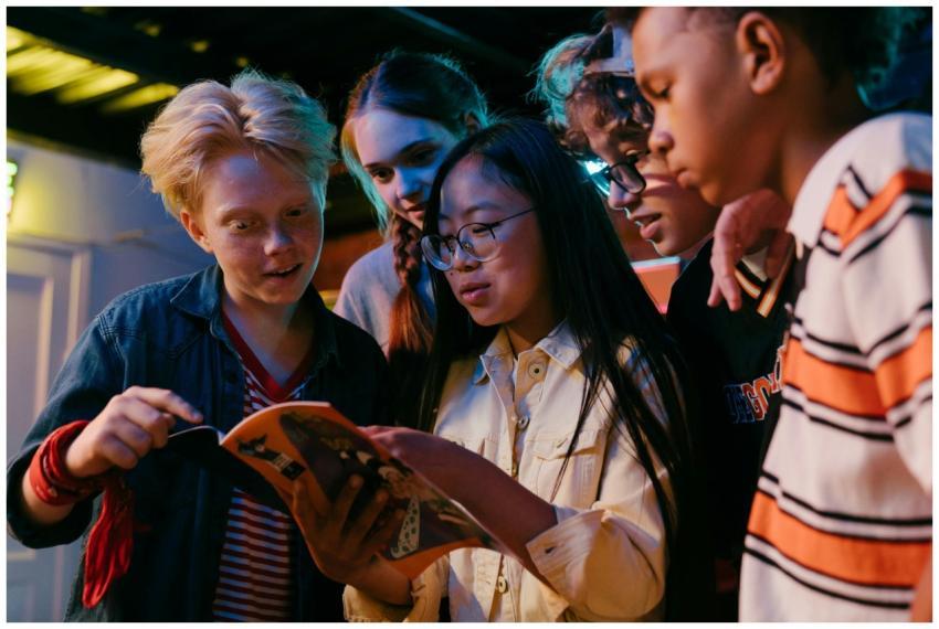 A diverse group of teenagers enthusiastically read
