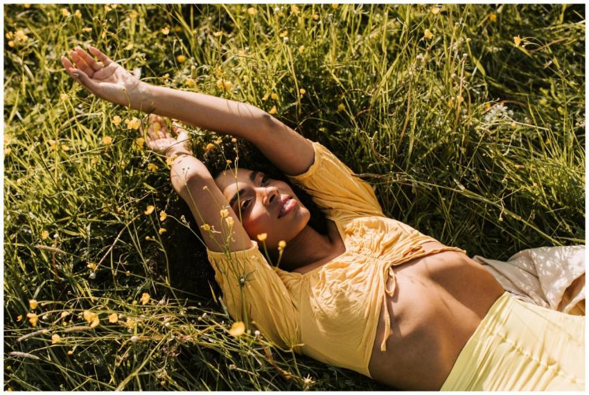 An African American woman wearing a yellow crop to