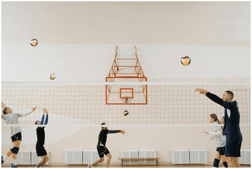 A group of young adults practicing volleyball indo