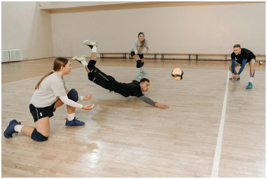 Four volleyball players engaged in a dynamic indoo