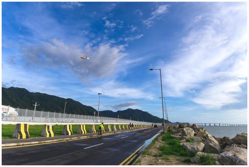 Cyclist rides along a scenic road in Kowloon, Hong