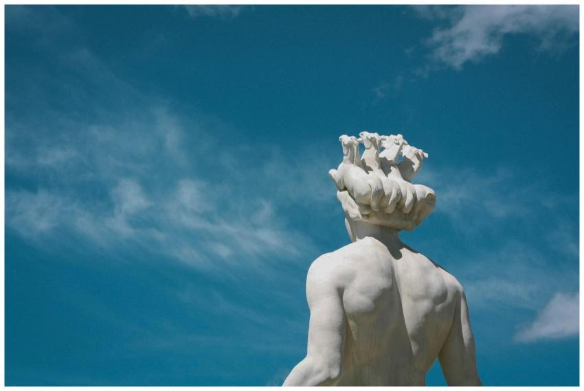 Low-angle view of a Greek statue on a sunny day wi